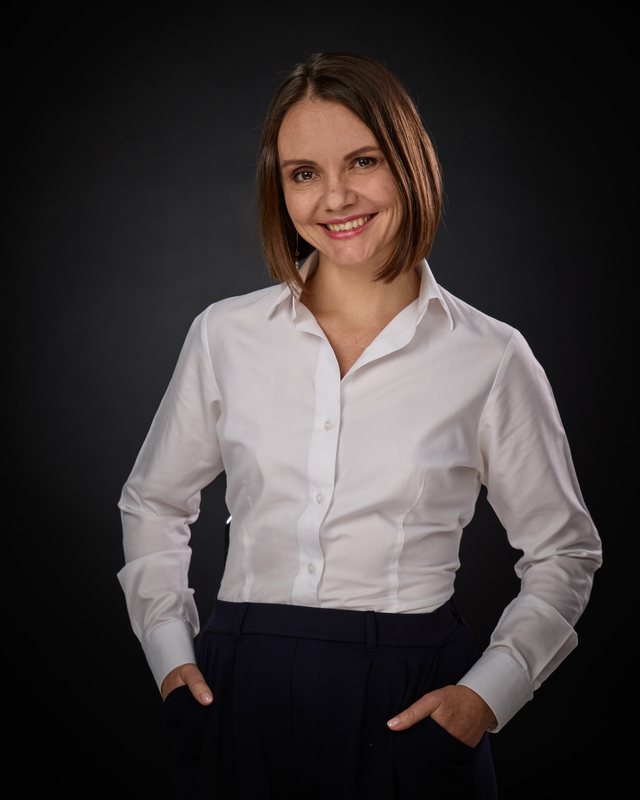 Agnieszka Baran uśmiechnięta, z dłońmi w kieszeniach
